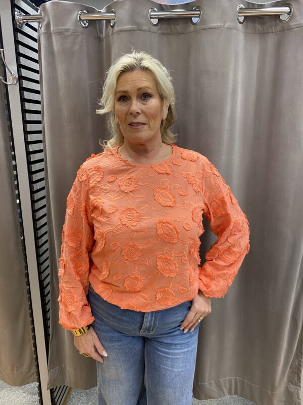 Orange blus med blommor