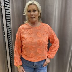 Orange blus med blommor